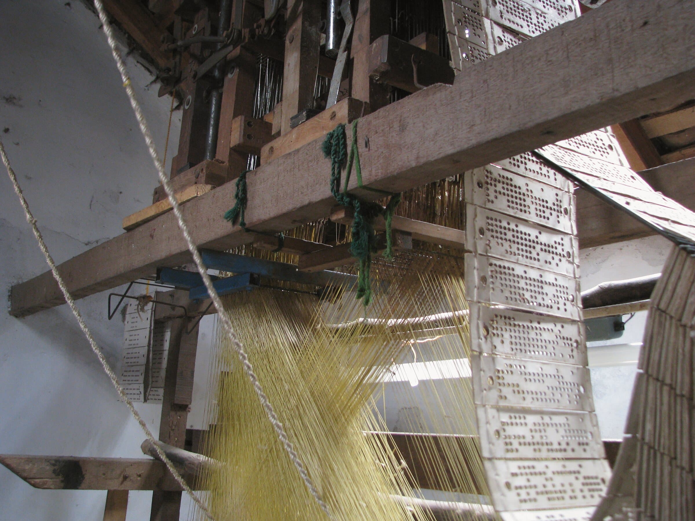 A complex silk handloom in Kanchipuram, Tamil Nadu, strung with hundreds of warp threads and pattern cords.