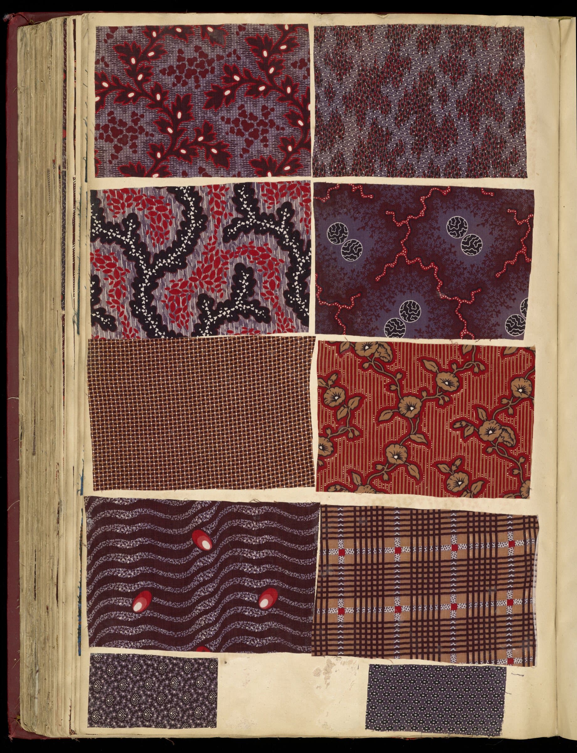 Page from a French fabric sample book of 1850 with ten printed cotton swatches in red, black and violet florals.